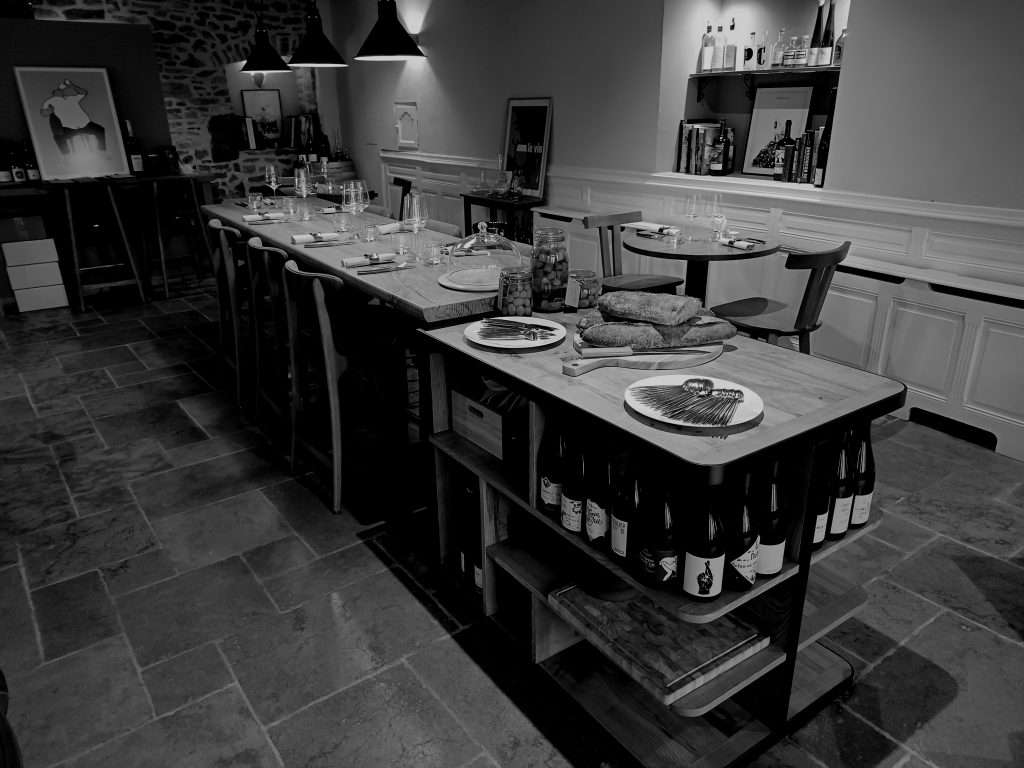 Agencement de restaurant au style industriel, avec chaises hautes en cuir marron et tables en bois et métal, créant une ambiance chic et chaleureuse.
