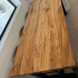 Gros plan sur les veines et le grain spectaculaires du plateau en olivier massif de la table AIX.