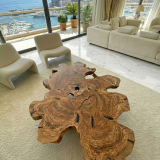 Table basse Ramatuelle en bois d'olivier massif à la forme brute et sinueuse, vue de dessus dans un salon lumineux.