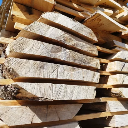 Plateaux de bois brut en hêtre en cours de séchage pour la fabrication de tables artisanales.